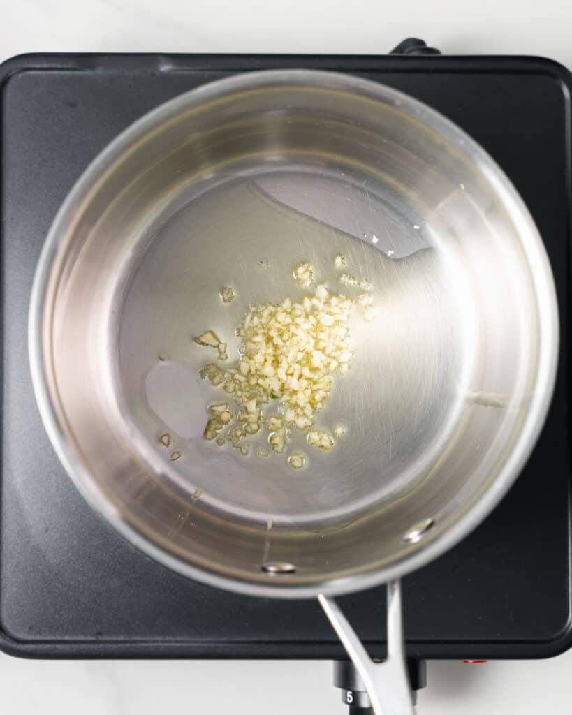 Garlic and olive oil in a pot.