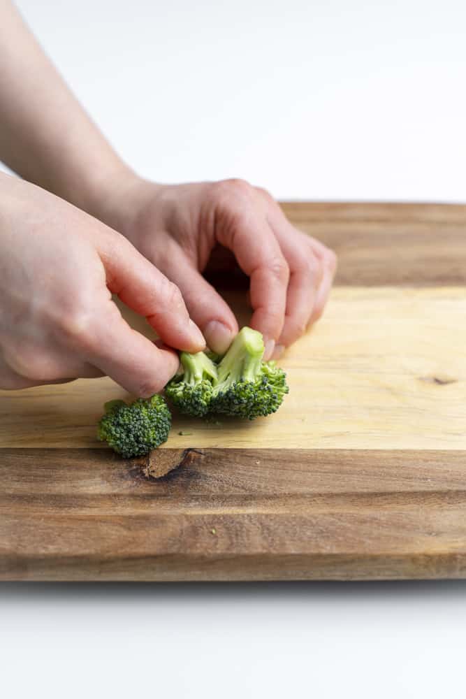 Pulling apart a larger floret with fingers to have two separate pieces.