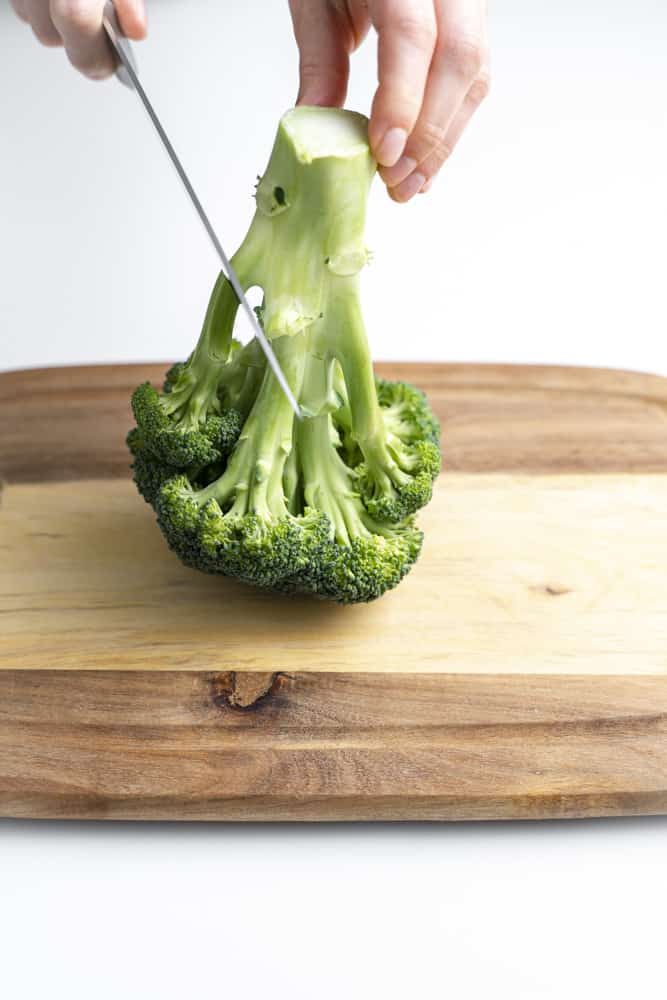 Slicing the stalk off of a head of broccoli.