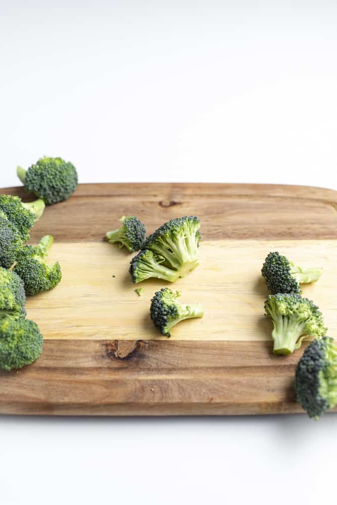 Small broccoli floret on a cutting board.