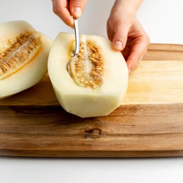 scooping the seeds out of the cantaloupe with a spoon