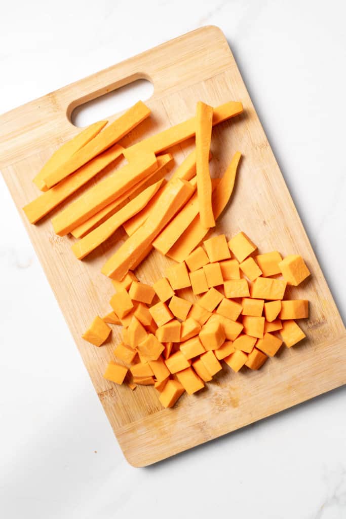 Cubes and sticks of sweet potato on a cutting board.