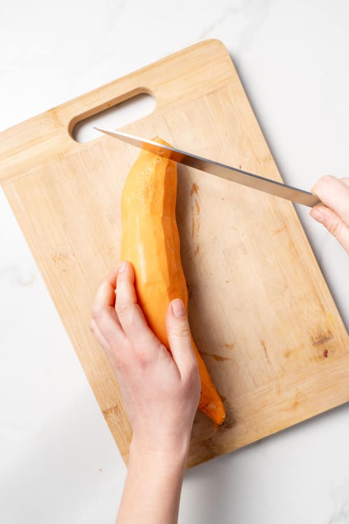 Slicing off the end of a sweet potato.