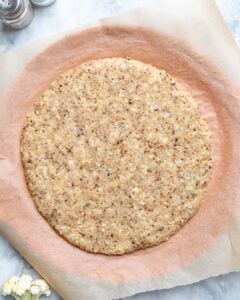 Place cauliflower dough on a baking sheet and pat it into a 13-inch circle.