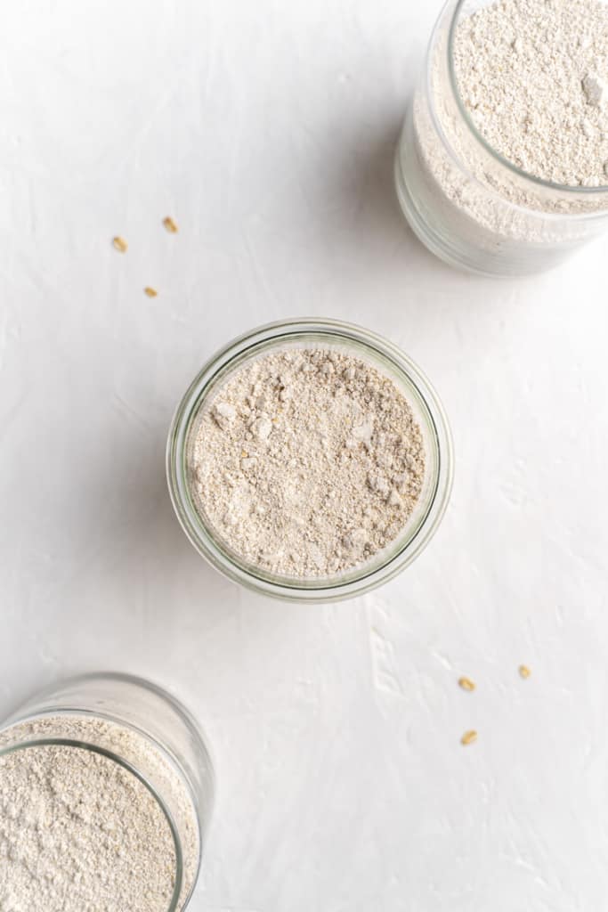Top view of oat flour in a glass jar with the lid off.