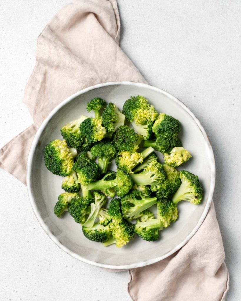 steamed broccoli florets on a round plate 