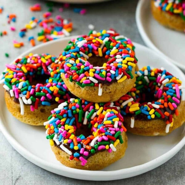 side shot of 5 protein donuts stacked over each other on a plate