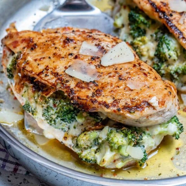Stuffed chicken breast with broccoli and cheese on a stainless steel pan.