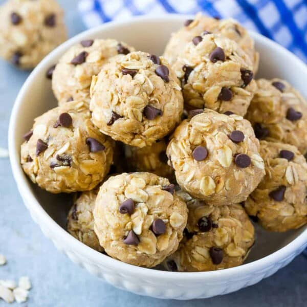 Energy bites made of oatmeal, peanut butter, and chocolate chips in a round white bowl.