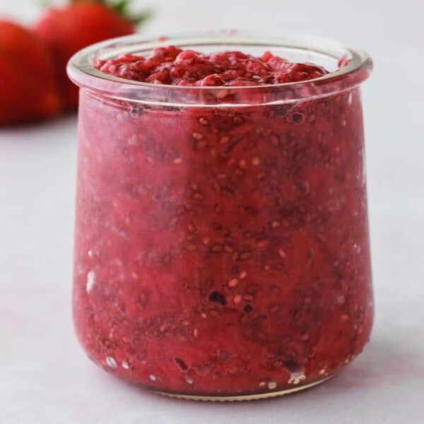 side view of strawberry jam in a jar that is red in color