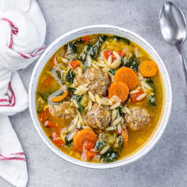 Italian wedding soup in a white round bowl.