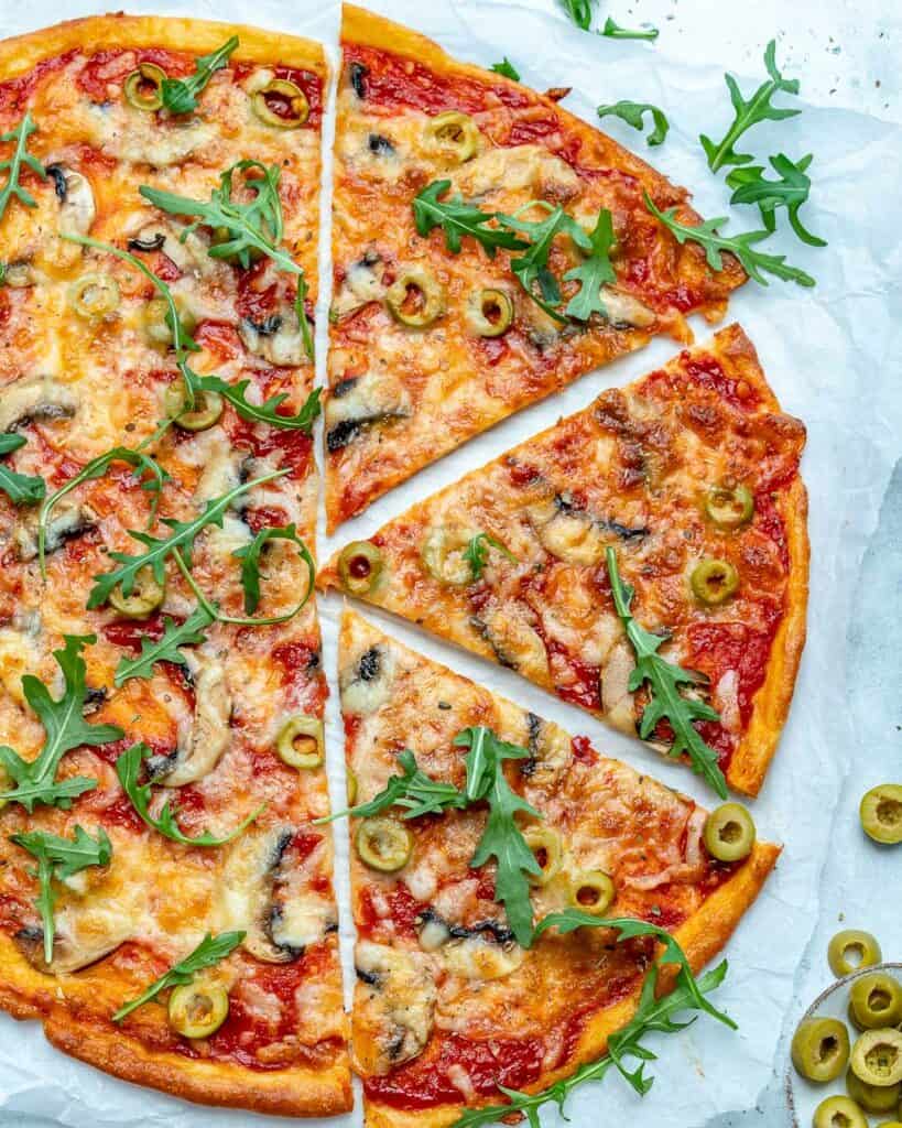 top view of a full baked thin crust pizza with the right side of it slices into 3 slices 