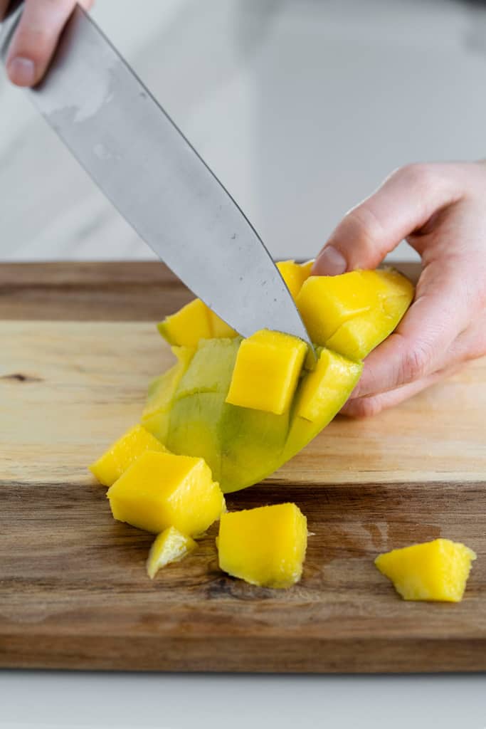 knife slicing off mango piece off skin