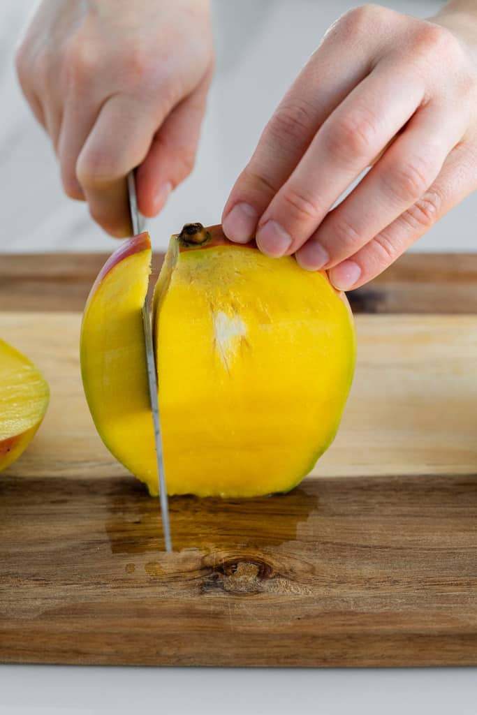 side of mange being sliced with a knife