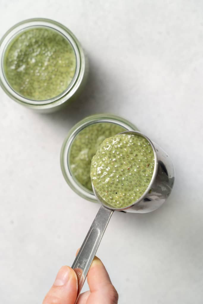 measuring up with matcha pudding mix being added in a jar