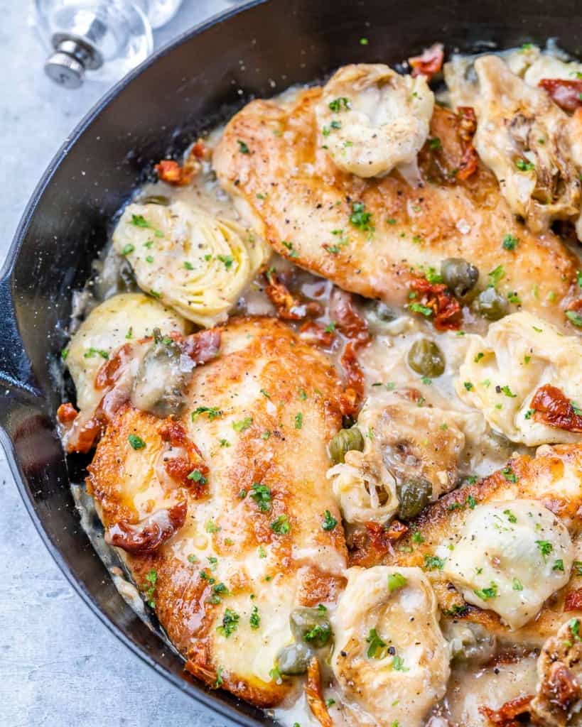 side shot of chicken in a creamy lemon sauce with artichoke