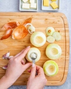 Onions being cored on a cutting board.
