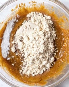 protein powder added over peanut butter dough in a bowl.