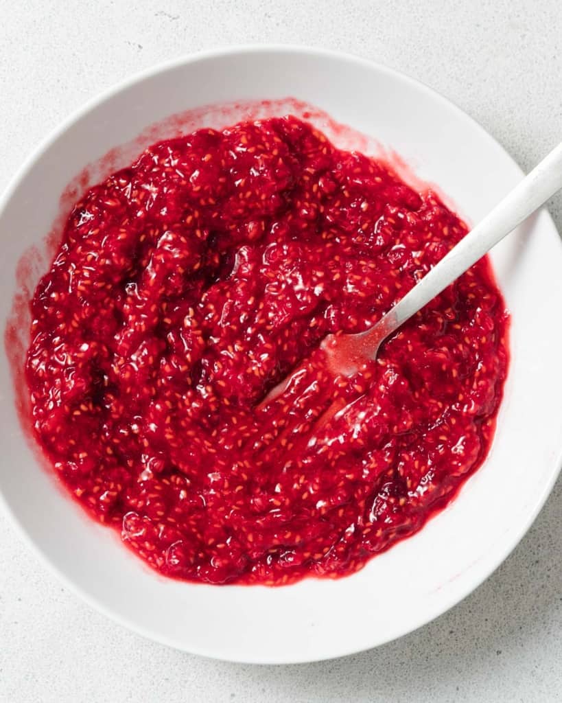 Using a fork to mash raspberries.