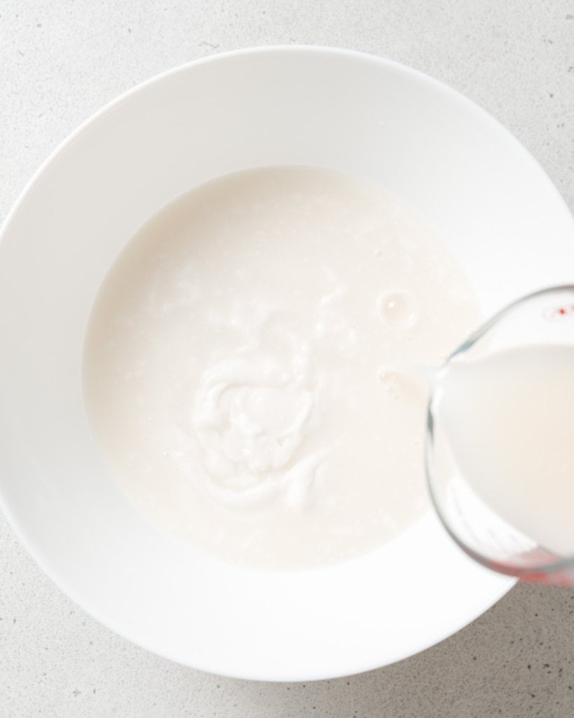 Adding milk to yogurt.