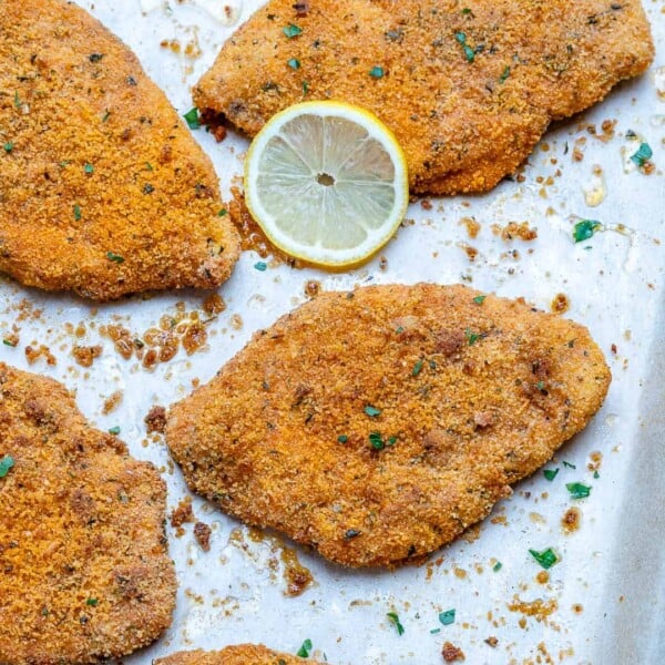 4 chicken cutlets baked on a sheet pan.