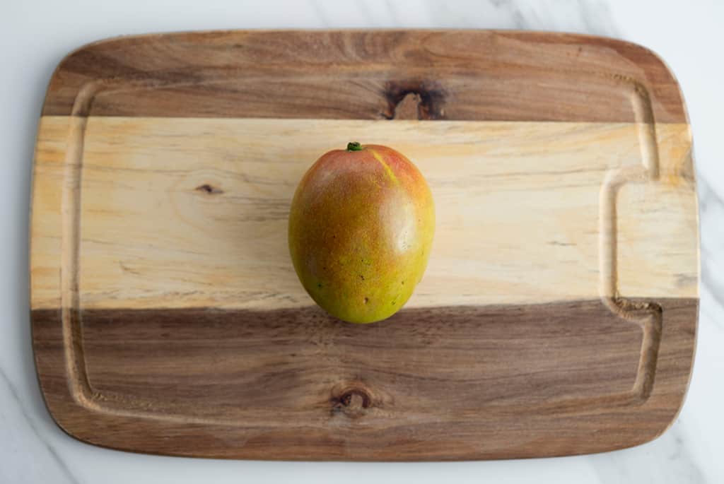 top view of one mango in a cutting board