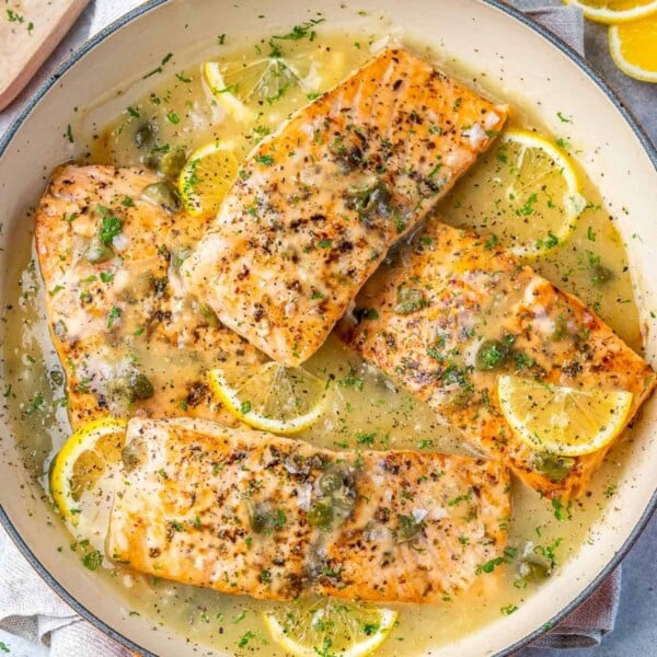 top view salmon piccata on an orange dish