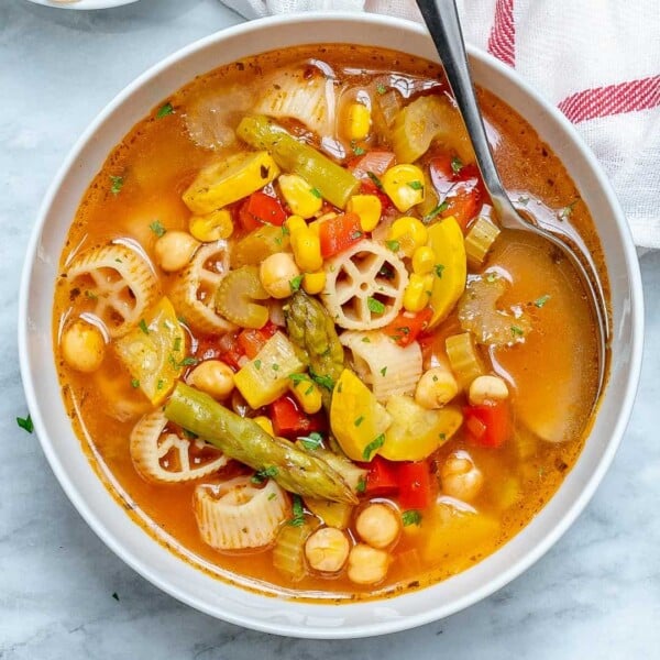 veggie soup in a round bowl with a spoon in it.