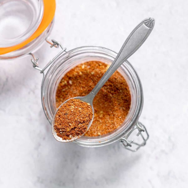 taco seasoning in a jar with a spoonful over the jar.
