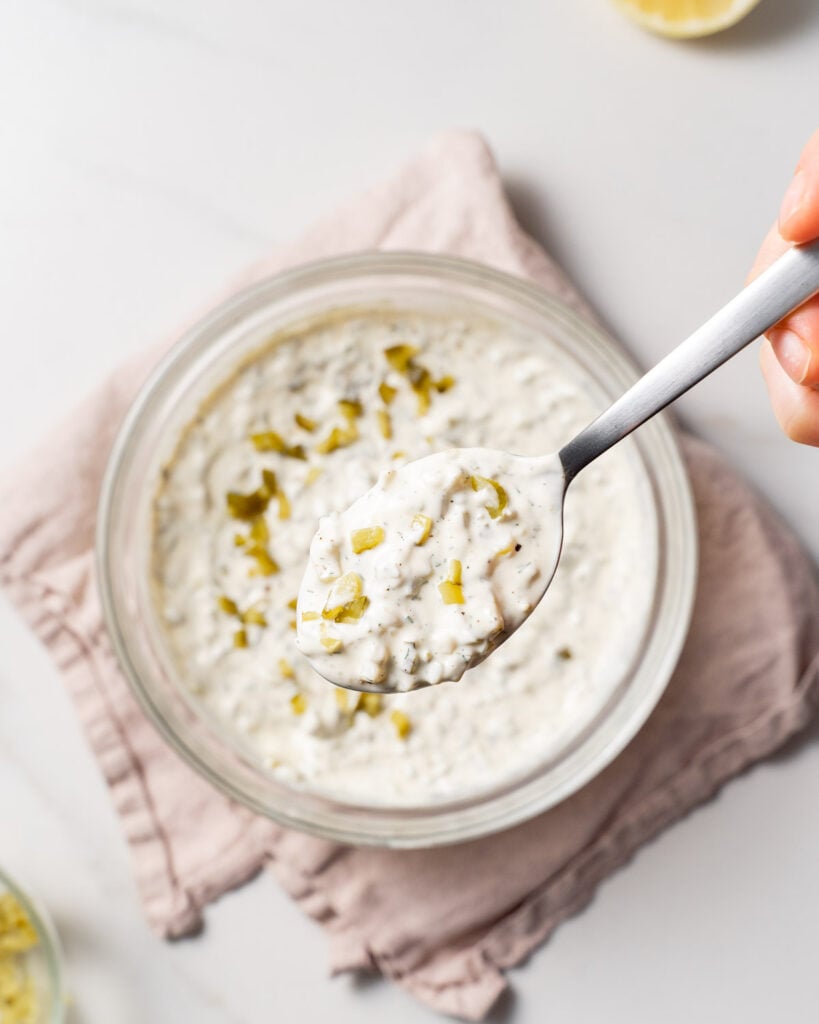 spoonful of tartar sauce over a bowl 