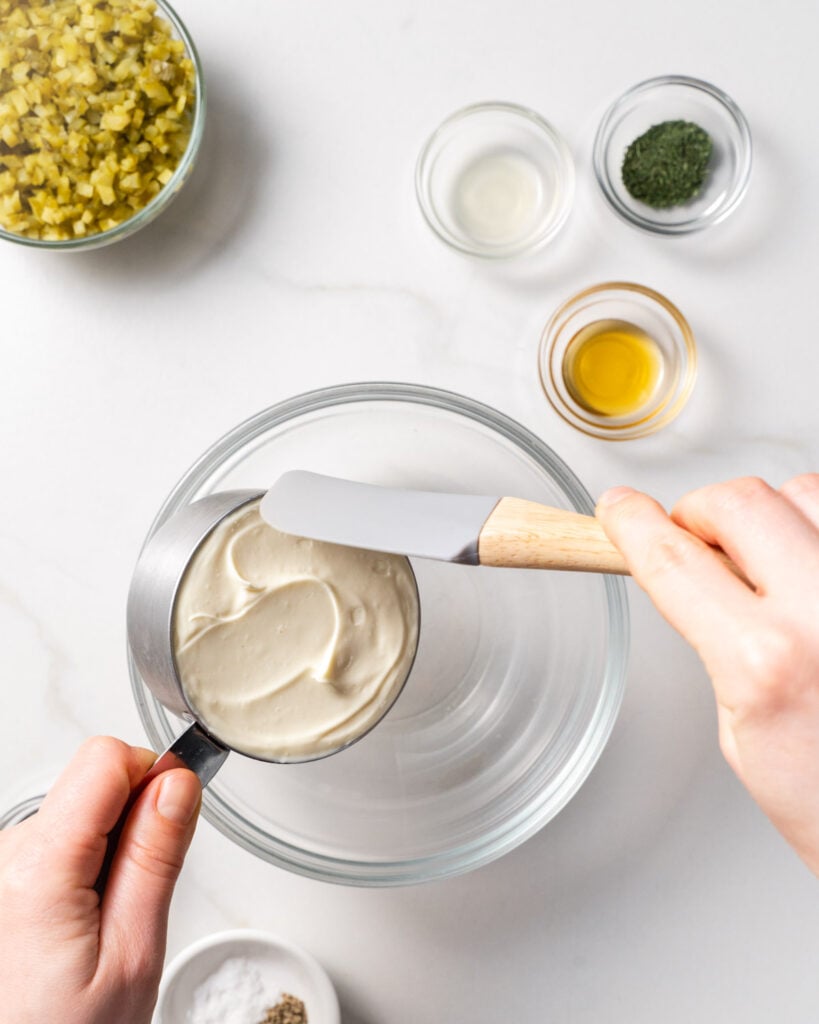 spatula removing mayo from measuring cup into the bowl