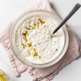 tartar sauce in a clear bowl with a spoon in the bowl.