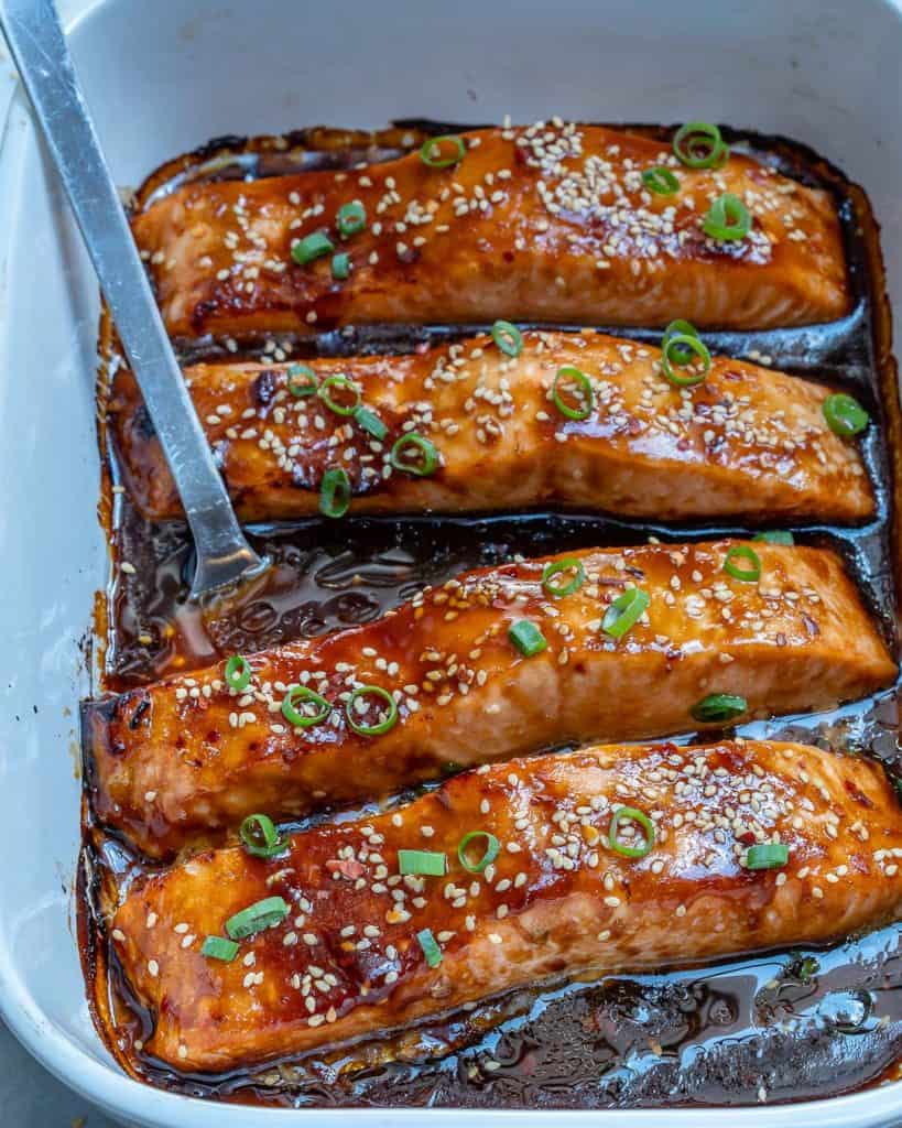 metal spatula in a white dish with baked salmon in teriyaki sauce 