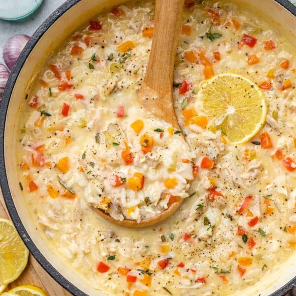 rice and turkey soup in a red pot with a spoonful of soup