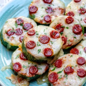 zucchini pizza bites slices topped with melted cheese and mini pepperoni.
